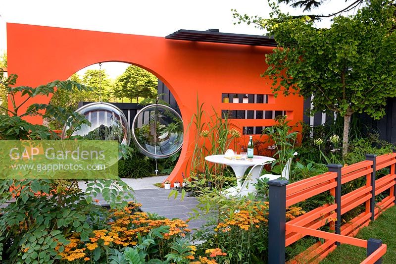 Creations Mid Century Modern - Best Low Cost High Impact Garden. RHS Hampton Court 2013. Orange moongate wall divider. Design: Adele Ford and Susan Willmott Sponsor: Outdoor Creations
