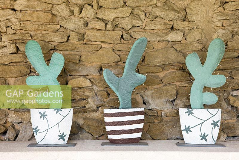 Decorative wooden cacti next to stone wall in pool house 