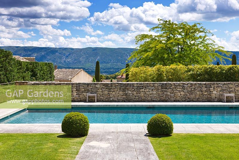 Lawn and path to swimming pool, Luberon hills behind. 