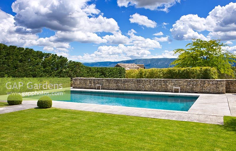Lawn and path to swimming pool with Luberon hills behind. 