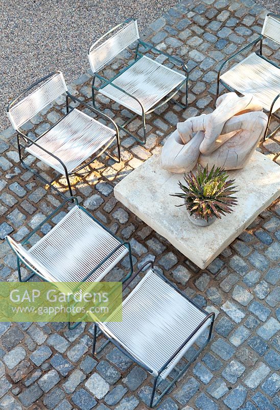 View of cobbled seating area with wooden sculpture. USA, August.