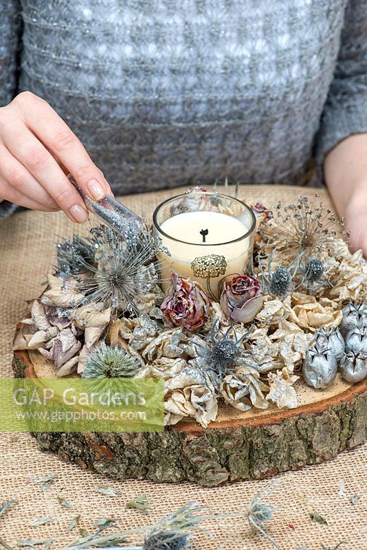 Creating a festive table decoration with garden flowers and seed heads. Finish with a sprinkling of silver glitter.