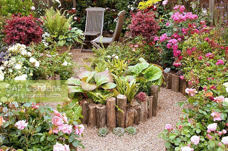 Sunken meandering path leading to a secluded seating area in the 'Rosy Hues' garden. RHS Tatton Flower Show 2015