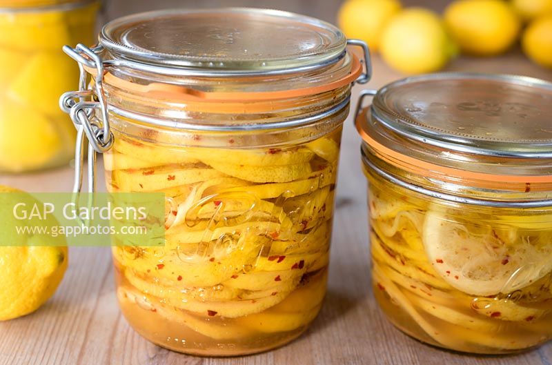 Jars of preserved sliced lemons preserved in olive oil, chilli flakes and salt.