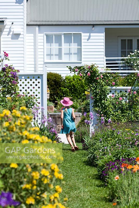 Girl running through English cottage style garden