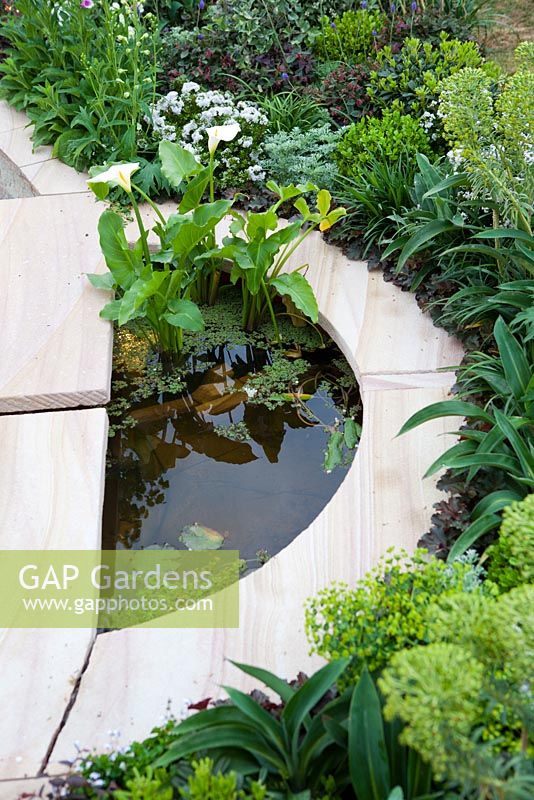 Sunken sandstone garden bed with curved edges and a semi-circular water feature.