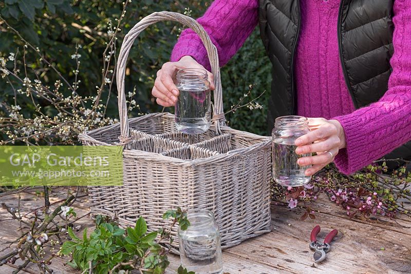 Place the jars with water into each section within the wicker basket