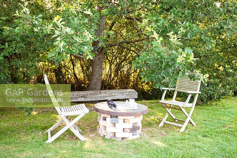 Chairs, bench and table with chess board under oak tree - July, Les Jardins de la Poterie Hillen