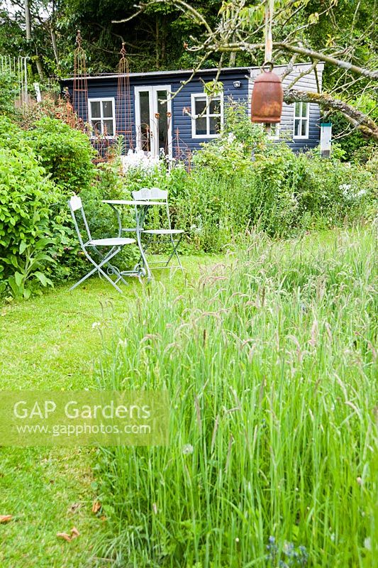 The Wild Garden where grass is allowed to grow long and bulbs are naturalised, with Debbie's studio in the corner.
