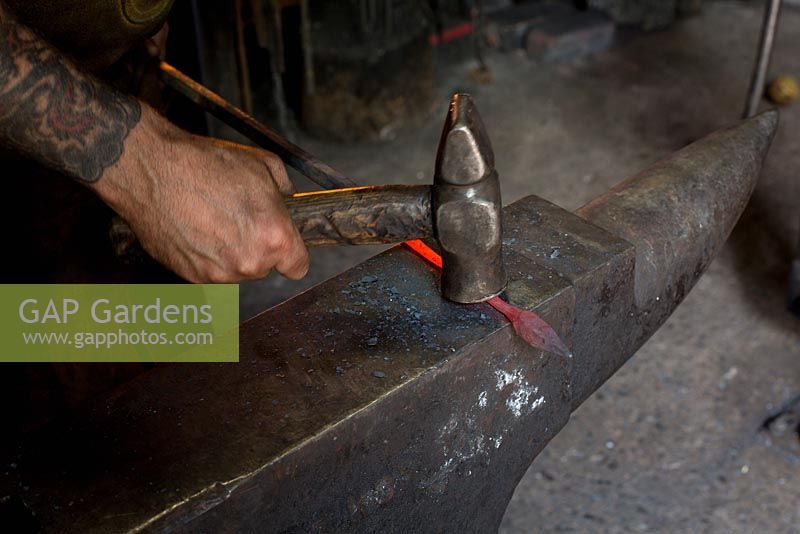 Paul Gilbert, blacksmith and sculptor, in his workshop making leaf figure from metal rod