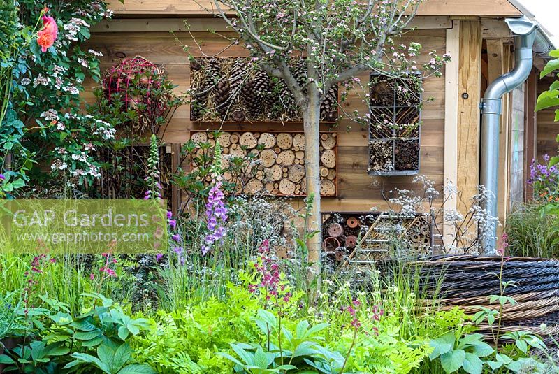 Bug hotels surrounded by planting in the RHS Greening Grey Britain for Health, Happiness and Horticulture Garden. RHS Chelsea Flower Show 2016 - Designer: Annie-Marie Powell