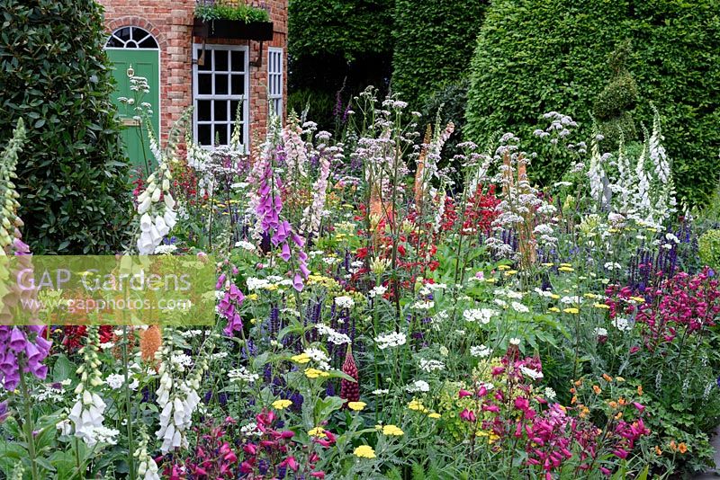 The Harrods British Eccentric Garden. Cottage garden with spring flowering perennials. RHS Chelsea Flower Show 2016, Designer: Diarmuid Gavin, Sponsor: Harrods