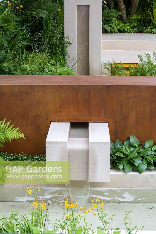 Garden of Mindful Living with limestone rill water feature and corten steel wall, planted with Primula, Sagina 'Senior and Hosta 'Devon Green'. The RHS Chelsea Flower Show 2016 - Designer: Paul Martin - Sponsor: Vestra Wealth LLP - GOLD