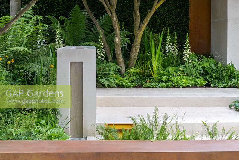 Garden of Mindful Living with limestone rill water feature and corten steel wall, planted with Blechnum tabulare, Primula, Sagina 'Senior', Matteuccia struthiopteris, Dryopteris erythrosora, Digitalis 'Dalmatian White' and Hosta 'Devon Green'. The RHS Chelsea Flower Show 2016 - Designer: Paul Martin - Sponsor: Vestra Wealth LLP - GOLD