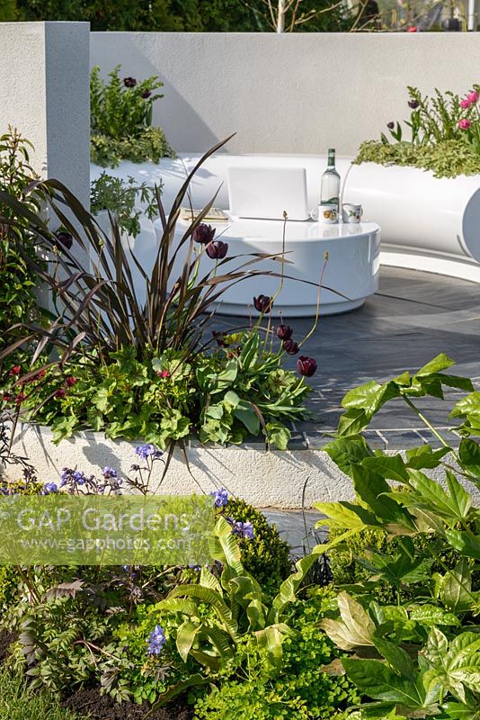 Curved seating area with white Halo seats and planters and mixed planting - Hidden Gems of Worcestershire, RHS Malvern Spring Festival 2016. Design: Nikki Hollier. Silver, Best Festival Garden