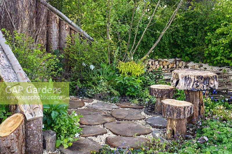 Table, stools and stepping stones made from tree trunks at The Woodcutter's Garden, RHS Malvern Spring Festival 2016. Design: Mark Walker