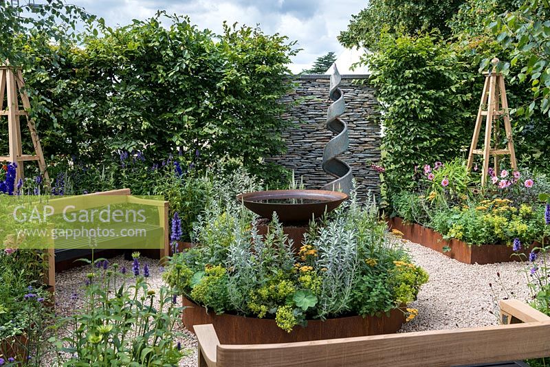 An Arts and Crafts inspired garden room with water feature, raised corten steel beds and hand crafted benches. A Summer Retreat designed by Laura Arison and Amanda Waring. Hampton court flower show 2016