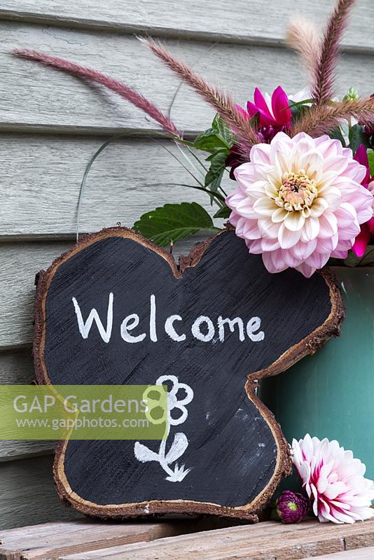 Oak tree slice painted and decorated to display 'Welcome' with Dahlia arrangement