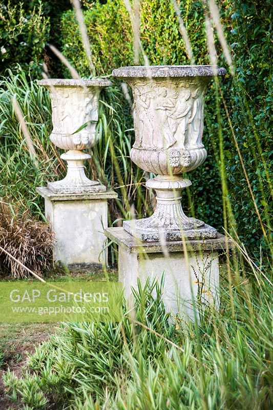 A pair of urns mark the entrance to the privet walk.