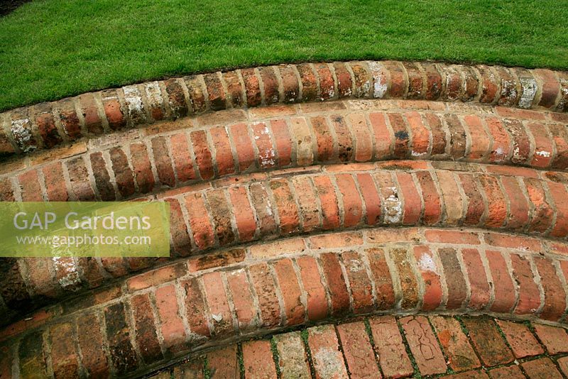 Curving steps linking a patio to a lawn built from recycled bull-nosed bricks. Design: David Green and Elaine MacKenzie.