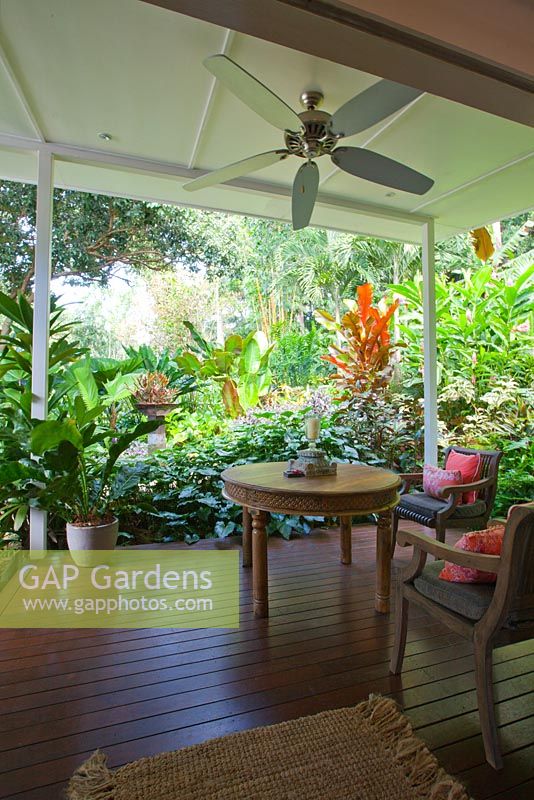 Outdoor deck with timber seating a ceiling fan at a Bed and Breakfast accommodation in tropical northern Australia. 