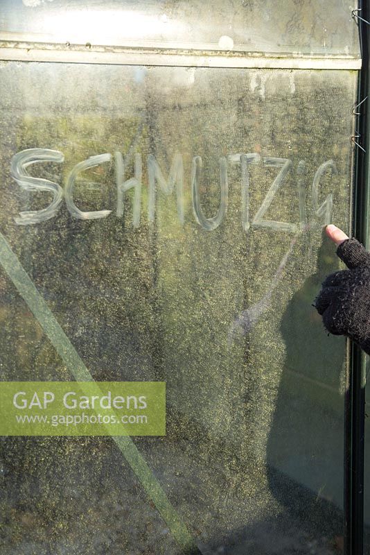 Writing 'Schmutzig' on a dirty greenhouse glass pane