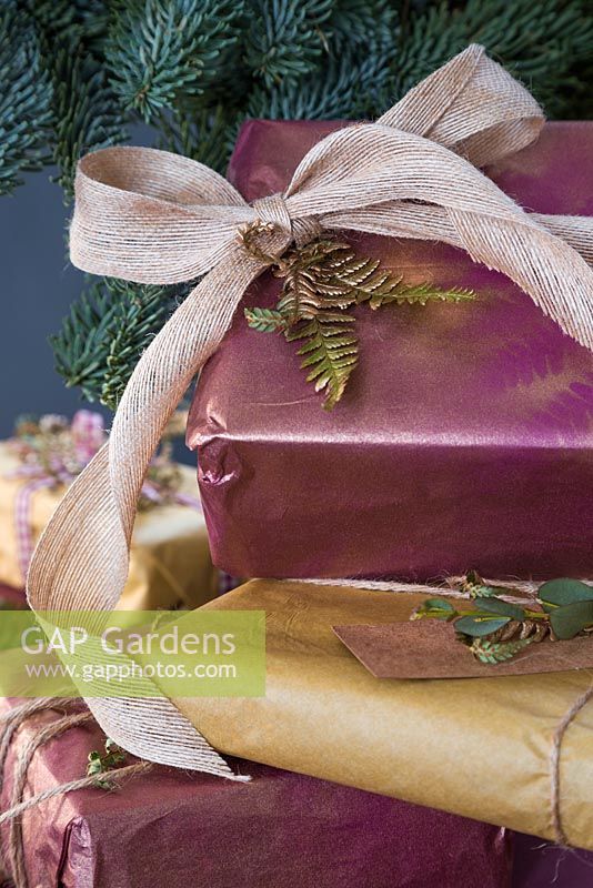 A variety of wrapped presents with Fern foliage and Eucalyptus, with spray painted imprint of a Fern