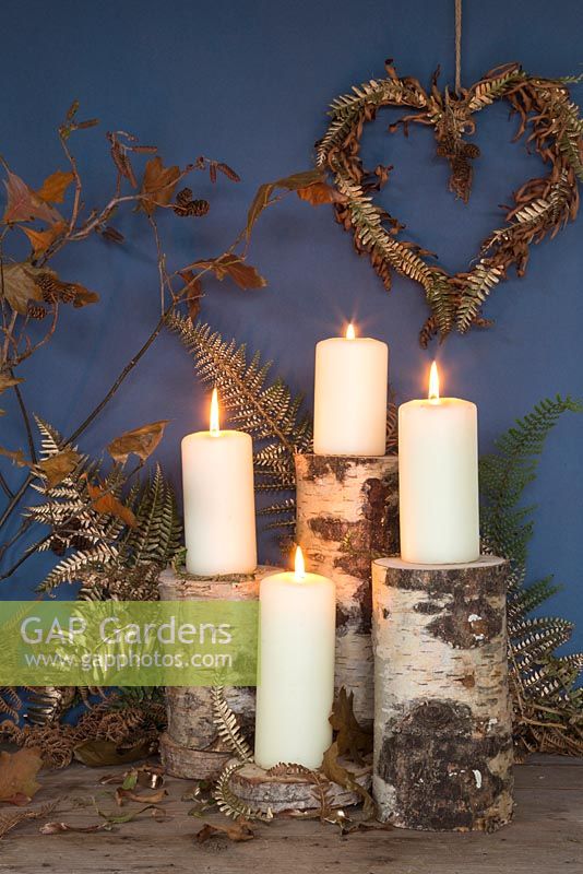 A wreath made with gold spray painted Fern foliage and dead fern foliage, with candle lit display
