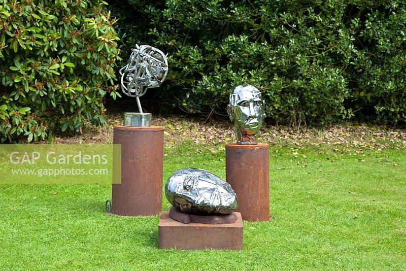 Metal head sculptures by Hilary Cartmel displayed on the croquet lawn at Bolham Manor, Nottinghamshire