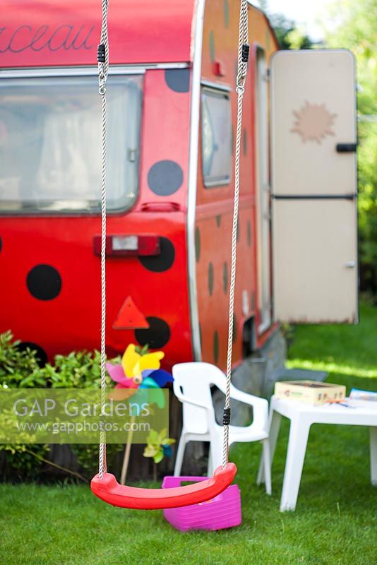 Swing in a childrens playground with a Ladybird trailer.  