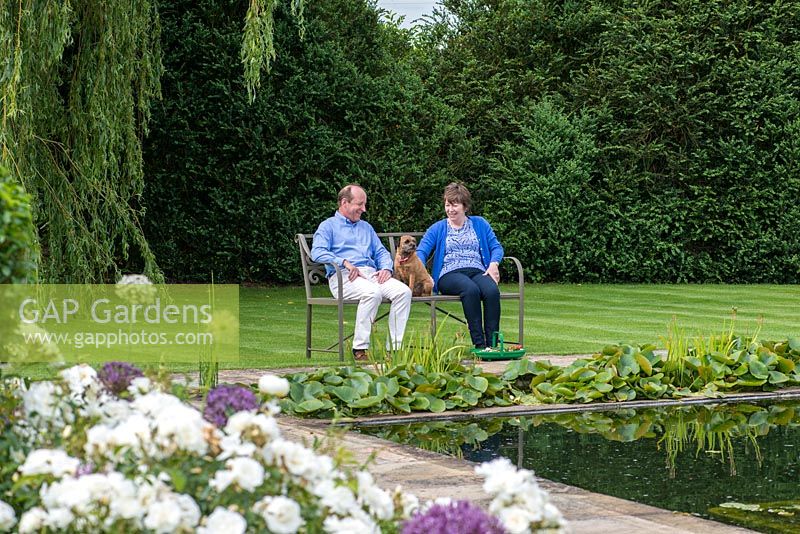 Mark and Angela Chambers, overlooking their rose garden and pool at Bretforton Manor.