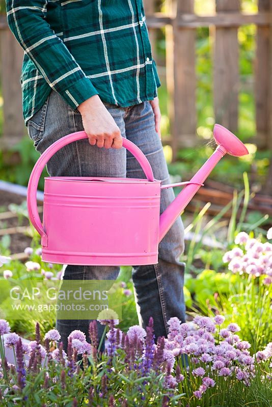 Woman carrying a watering can.