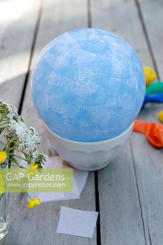 Making paper lanterns - Apply a single layer of tissue paper, using the PVA glue, overlapping the pieces cut in to rough squares 3-4cm in size