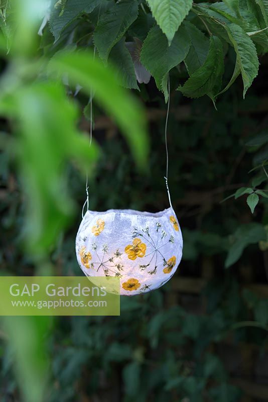 Making paper lanterns - Finished paper lantern with tealight hanging in garden