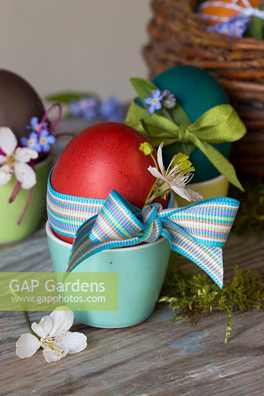 Decorated dyed Easter eggs with ribbon, dainty flowers and string