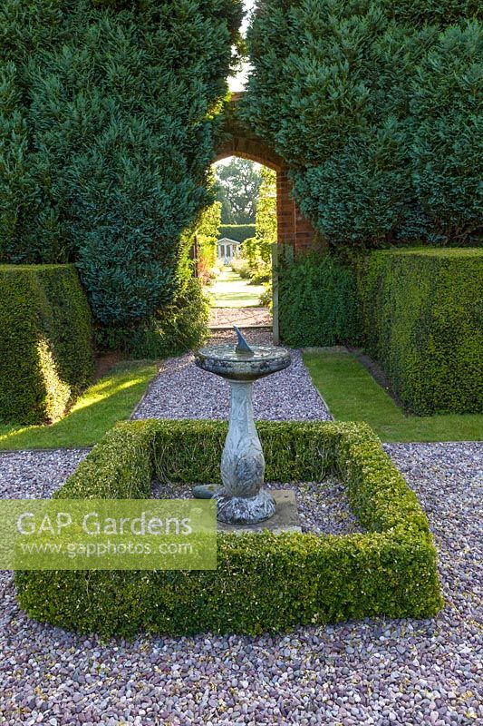 A gateway connects a renovated, pre-existing area to a newly created walled garden in a modern Cheshire country garden. It was designed by Louise Harrison-Holland. A sundial and summerhouse provide focal points while planting includes clipped yew and box hedging.