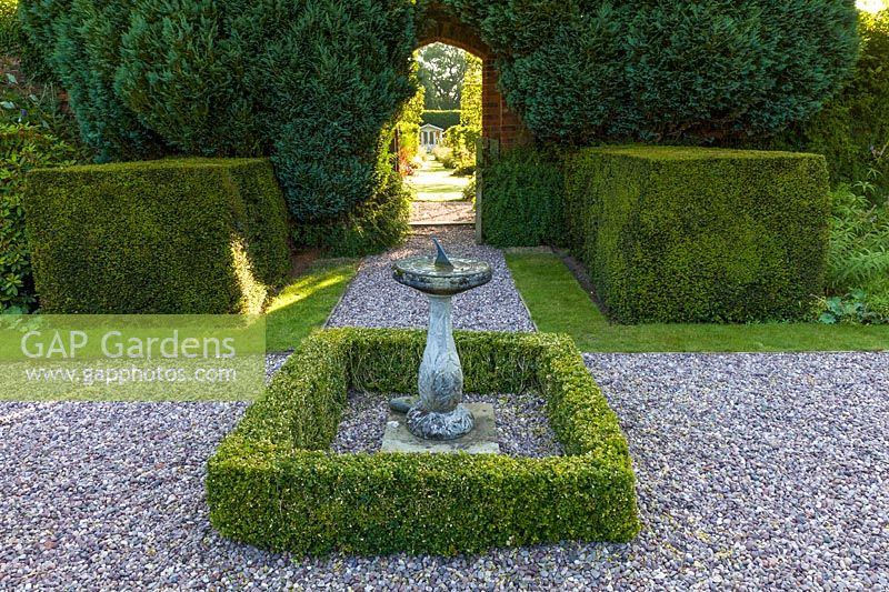 A gateway connects a renovated, pre-existing area to a newly created walled garden in a modern Cheshire country garden. It was designed by Louise Harrison-Holland. A sundial and summerhouse provide focal points while planting includes clipped yew and box hedging.
