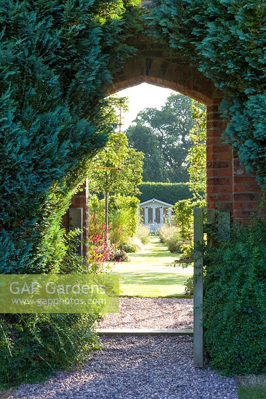 A gateway connects a renovated, pre-existing area to a newly created walled garden with a summerhouse, in a modern Cheshire country garden. It was designed by Louise Harrison-Holland
