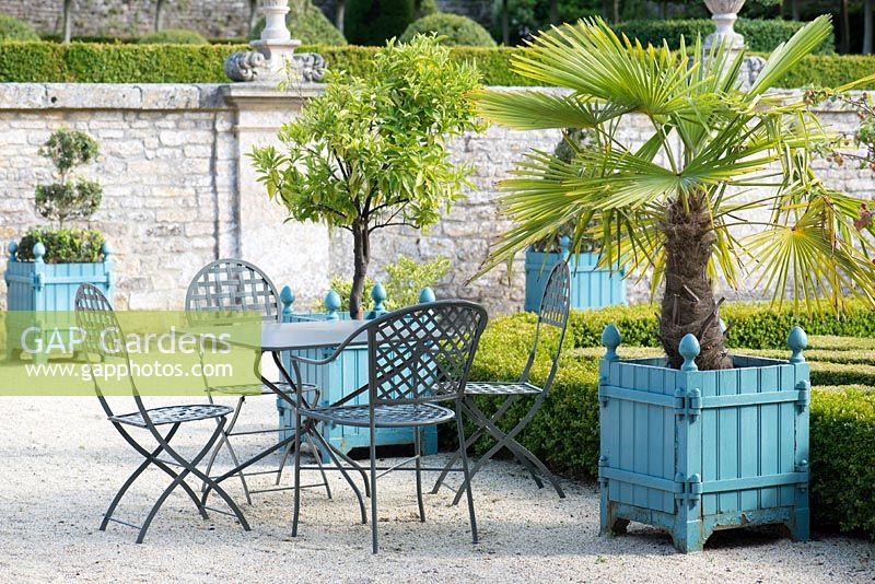 Seating and Versailles planters on gravelled area at Chateau Brecy, France