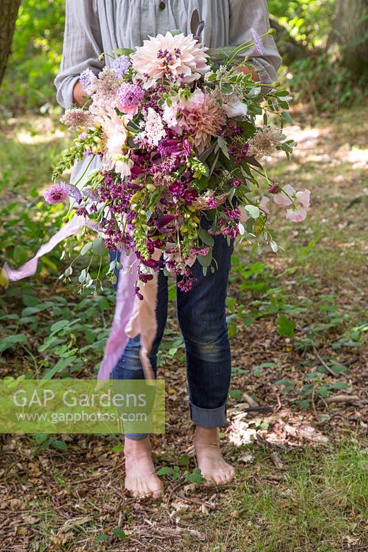 Woman holding natural bouquet with silk ribbons