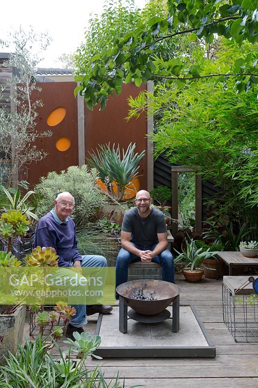Garden owner and designer Steven Wells, relaxing with his father Ken in front of the fire pit.