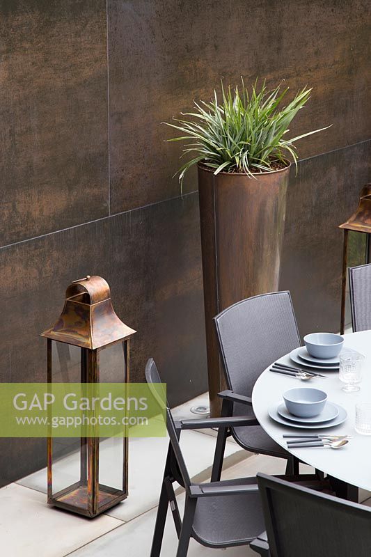 Copper feature wall, lantern and tall containers with Astelia