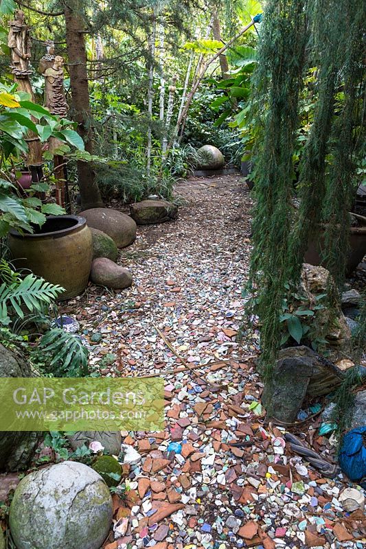 Pathway lined with broken pots and ceramics. Sculptor and ceramicist Marcia Donahue's garden in Berkeley, California.