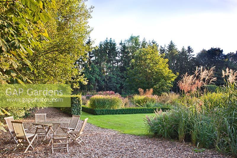 View of the garden in October: relaxing area and autumn borders.