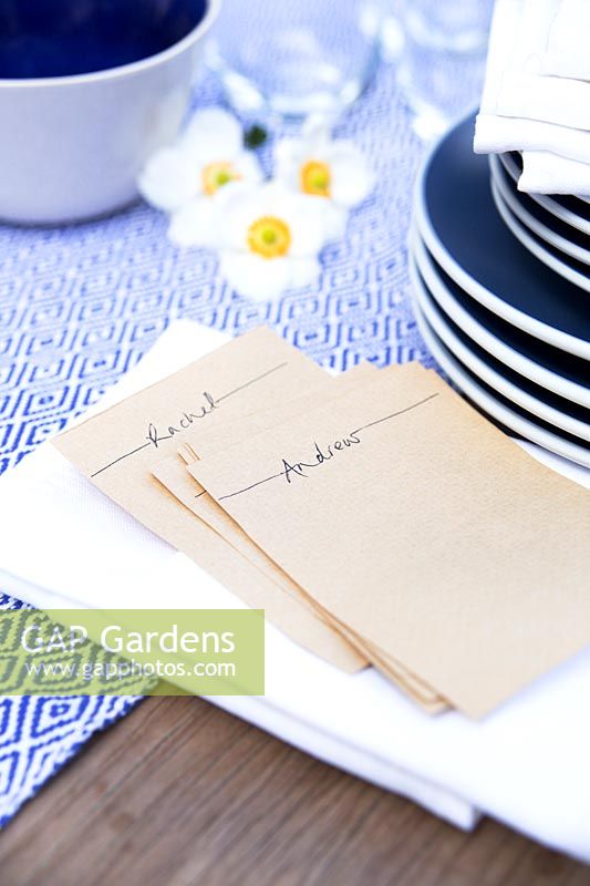 Blue crockery and white napkins with pockets folded to put a name card in them for dressing the table