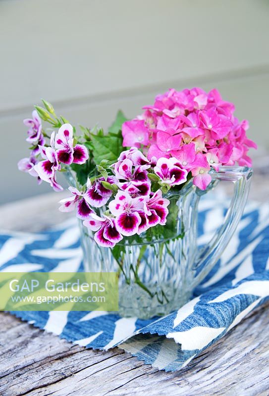 Pink geranium and hydrangea in a vintage glass jug