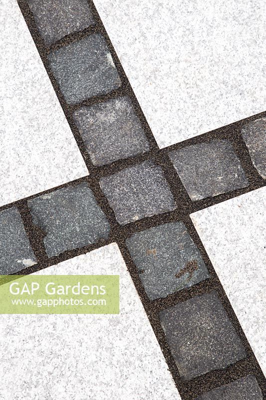Making a mixed material patio - detail of paving where large porcelain slabs are mixed with granite setts
