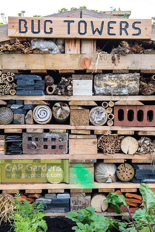 Bug hotel built from wood offcuts, leftover bricks, bamboo lengths, branches, straw and pipes. 