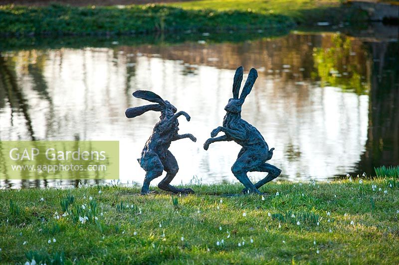 Boxing hares sculpture beside lake, Chippenham Park, Cambridgeshire.