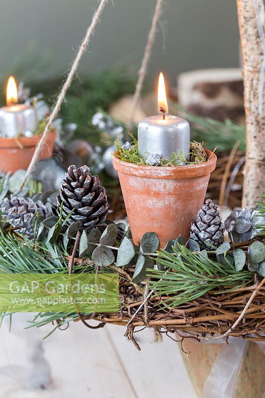 Close up detail of a lit rustic advent candle holder 